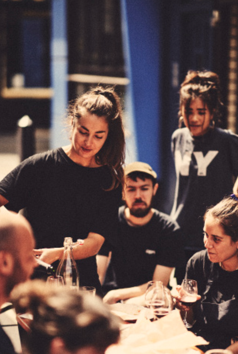 A server pouring drinks for guests