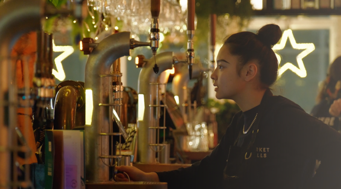 A bartender at the taps, mid-service